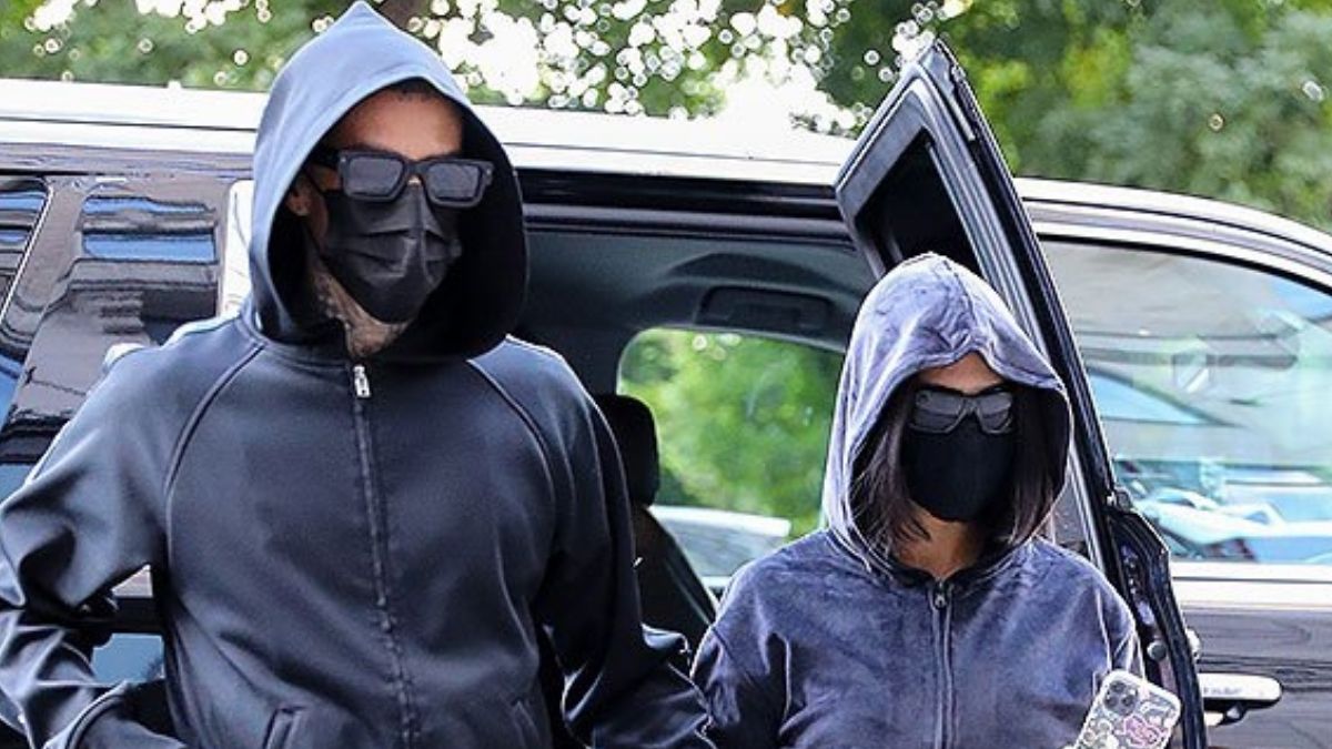 Kourtney Kardashian & Boyfriend Travis Barker Twin In Black Hoodies & Pants As They Arrive In NYC With Kim Kardashian